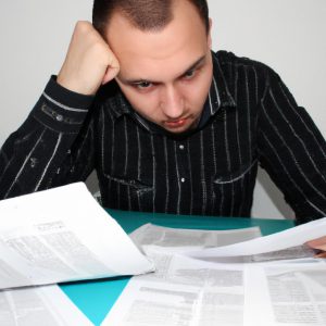 Person reviewing financial documents, stressed