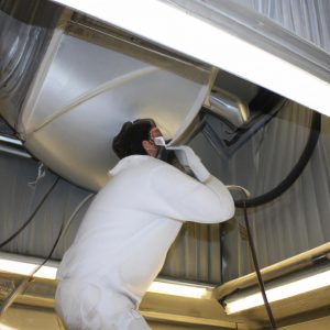 Person cleaning industrial HVAC ducts