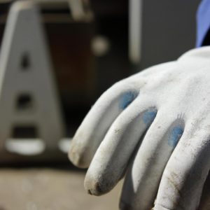 Person wearing safety gloves, working